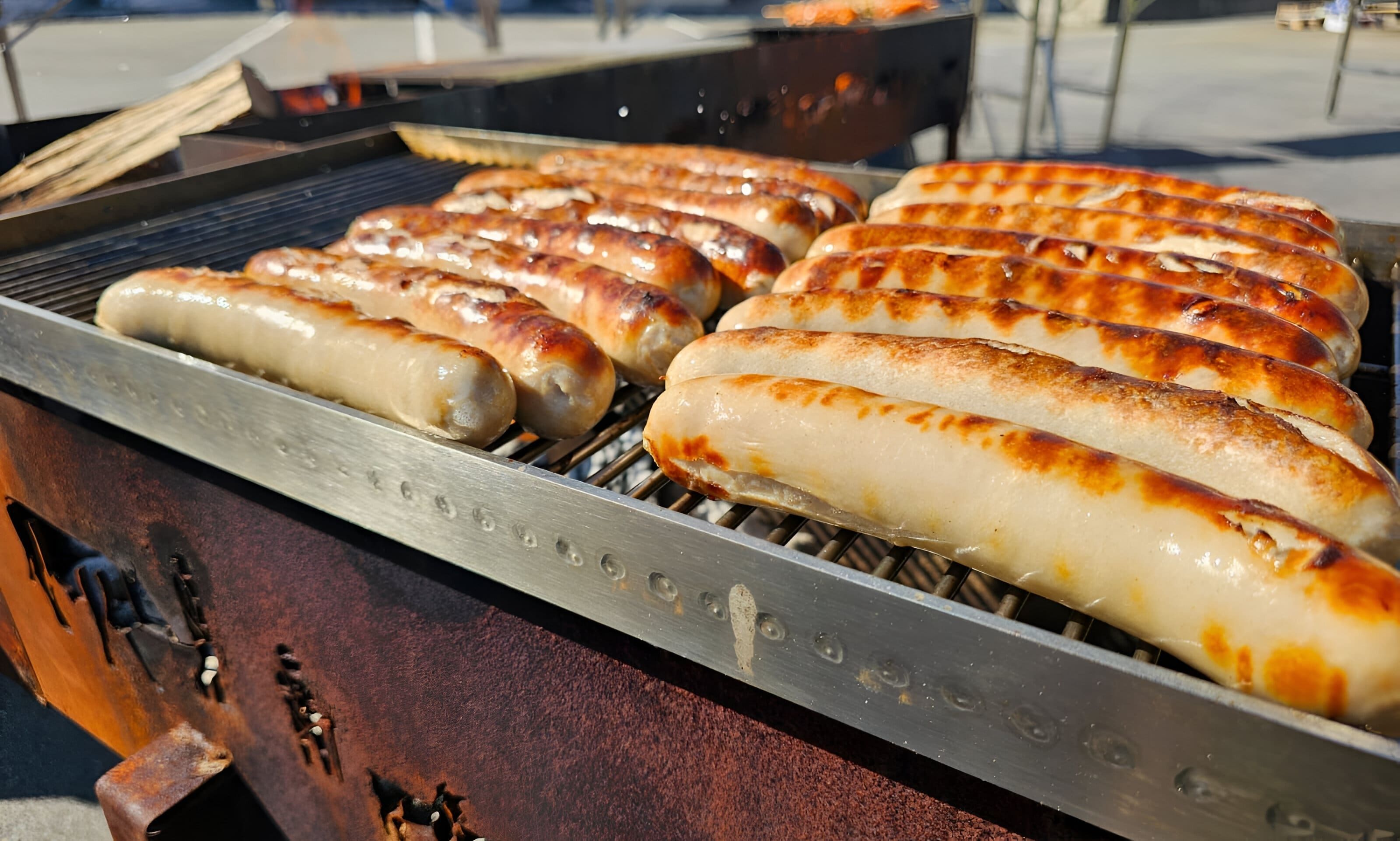 Nahaufnahme von fertigen Bratwürsten auf dem grössten Spiessgrill der Schweiz von unico swiss.